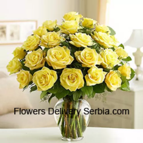 25 Yellow Roses With Some Ferns In A Glass Vase