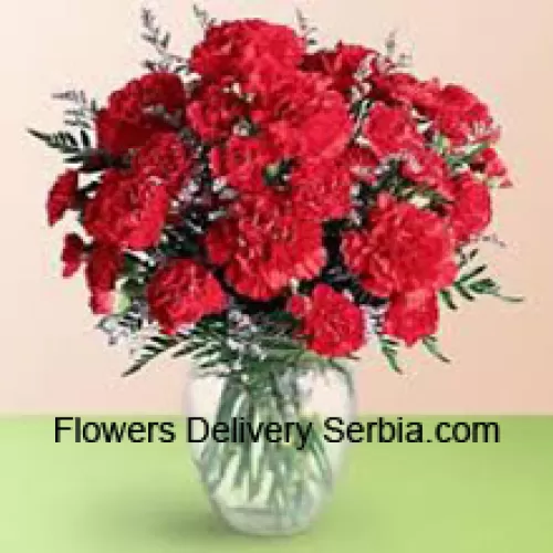 37 Red Carnations With Seasonal Fillers In A Glass Vase