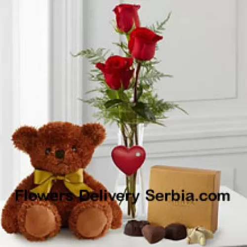 Trois roses rouges avec des fougères dans un vase, un mignon ours en peluche brun de 10 pouces et une boîte de chocolats Godiva. (Nous nous réservons le droit de substituer les chocolats Godiva par des chocolats de valeur égale en cas de non disponibilité. Stock limité)